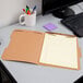 A brown Pendaflex letter size fastener folder with lined paper in it.