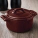 The brown lid of a Bon Chef burnt umber porcelain cocotte sitting on a brown pot.