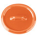 An orange Bon Chef porcelain oval lid with a handle.