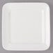 A white square Bon Chef porcelain plate with a white rim on a gray surface.