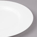 A close-up of a Bon Chef white bone china salad plate with a wide white rim.