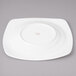 A white Bon Chef soft square porcelain dinner plate with a circular design.