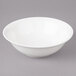 A white Bon Chef porcelain bowl with a white rim on a gray surface.