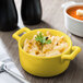 A yellow Bon Chef porcelain cocotte filled with macaroni and cheese.