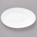 A white Bon Chef porcelain oval plate with a curved edge on a gray surface.