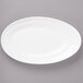 A white Bon Chef porcelain plate with a slanted oval shape on a gray surface.