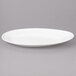 A close up of a white Bon Chef slanted oval porcelain plate with a fork.