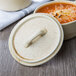 A white Bon Chef porcelain oval cocotte lid with a wheat design on top.