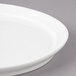 A close-up of a white Bon Chef porcelain plate with a rim.