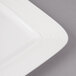 A close-up of a white rectangular porcelain plate with circles on the edge.