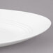 A close up of a white Bon Chef porcelain plate with a thin rim.