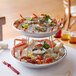 A two tiered tray of seafood on a table.