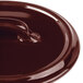 A close-up of a Bon Chef burnt umber porcelain oval cocotte lid with a handle.