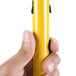 A person holding a yellow Rubbermaid HYGEN mop pole.