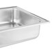A stainless steel water pan for a chafing dish on a white counter.