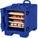 A navy blue Cambro food storage container with food on trays.