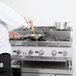 A chef cooking on a Cooking Performance Group gas countertop range.