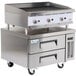 A Cooking Performance Group stainless steel gas lava briquette charbroiler over two refrigerated drawers.
