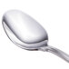 A close up of a Walco Luxor stainless steel demitasse spoon with a silver handle.