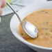 A Walco Luxor stainless steel bouillon spoon in a bowl of soup.