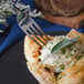 A Walco stainless steel dinner fork spearing a pastry with cheese and herbs.