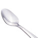 A close-up of a Walco stainless steel demitasse spoon with a silver handle.