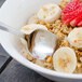 A Walco Meteor stainless steel teaspoon in a bowl of oatmeal with bananas and strawberries.