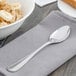 A Walco stainless steel teaspoon on a napkin next to a bowl of oatmeal with bananas.