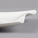 A close-up of a Villeroy & Boch white porcelain rectangular plate with a curved edge.