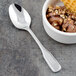 A Walco Saville stainless steel dessert spoon next to a bowl of chocolate ice cream.