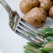A Walco Saville stainless steel dinner fork on a plate with potatoes and green beans.
