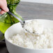 A Walco stainless steel serving spoon holds a bowl of white rice.