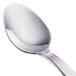 A close-up of a Walco Bosa Nova stainless steel demitasse spoon with a white handle.