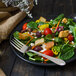 A salad with vegetables on a plate with a Walco Meteor stainless steel salad fork.