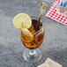 A glass of iced tea with lemon slices and a Walco Saville iced tea spoon.