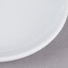 A close up of a Thunder Group white coupe melamine plate with a white rim.