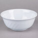 A white bowl with a white swirl pattern on a gray surface.