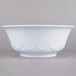 A close-up of a white Thunder Group melamine bowl with a scalloped edge.
