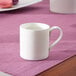 A white Villeroy & Boch Modern Grace bone porcelain cup on a purple placemat.