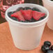 A Dart white foam food container filled with berries.