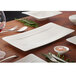 A white Villeroy & Boch Modern Grace rectangular plate with a knife and fork on a table.