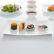 A Villeroy & Boch white bone porcelain sushi plate with sushi and salad on it.