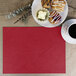 A red H. Risch, Inc. rectangular placemat with a plate of pastries and a cup of coffee.