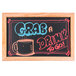 An Aarco oak-framed chalkboard with writing that says "grab a drink to go" on a counter.
