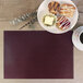 A plate of pastries and a cup of coffee on a customizable wine vinyl rectangle placemat.
