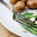 A Walco stainless steel dinner fork on a plate of green beans and potatoes.
