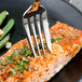 A Walco Prim stainless steel fish fork on a plate of food.
