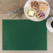 A plate of pastries and a cup of coffee on a green H. Risch, Inc. rectangular placemat.