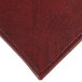 A close up of a customizable red faux leather rectangle placemat with a small hole in it.