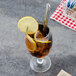 A glass of iced tea with a lemon wedge and a Walco Maremma iced tea spoon.